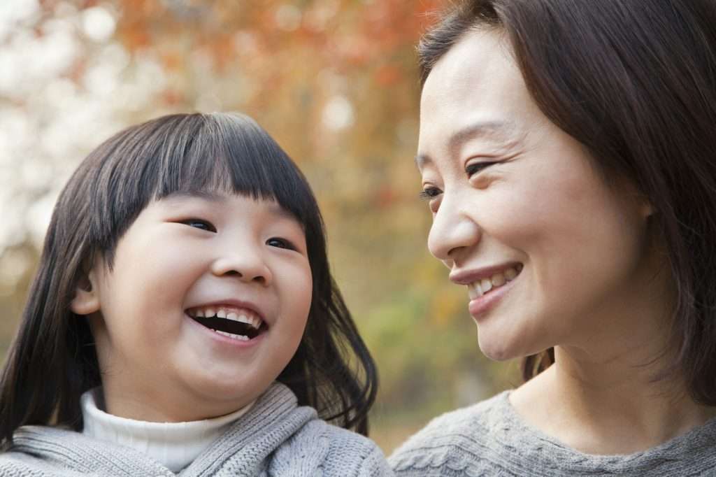 Close-up of Mother and Daughter laughing in the park, autumn, China