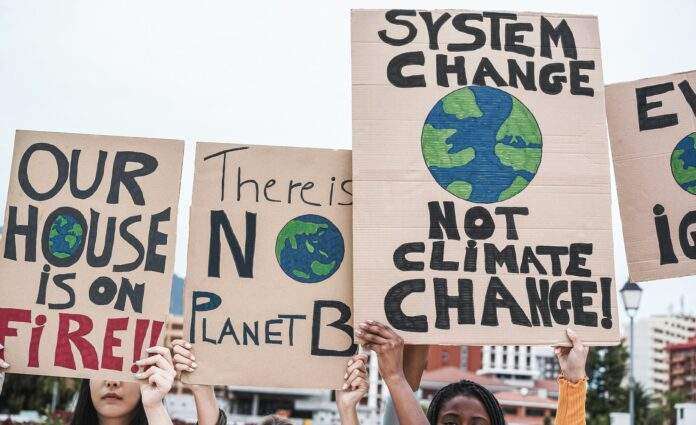 Young group of demonstrators on road from different culture and race fight for climate change